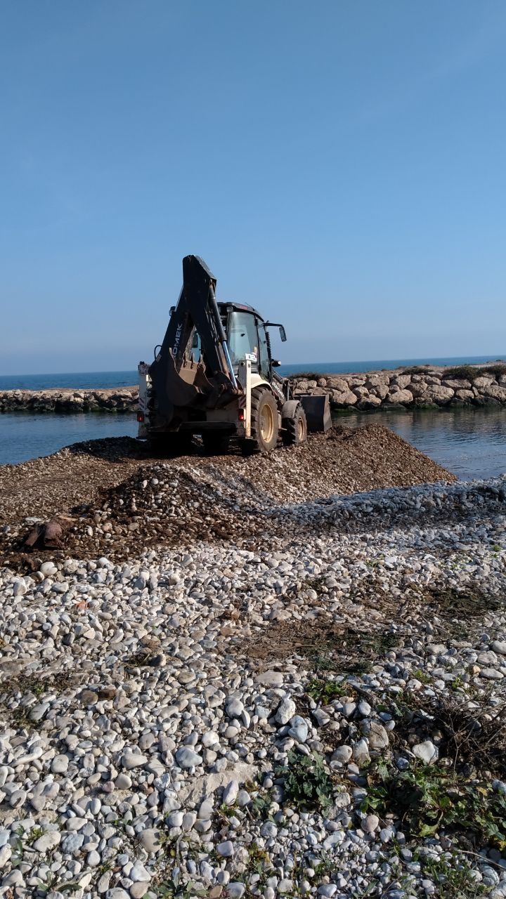 Trabajos de reconstrucción de la barrera de grava en la desembocadura del río Girona