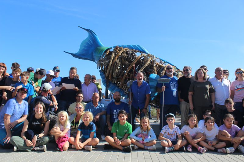 Fotografía de algunos de los asistentes a "Per una mar neta" con la escultura de R...
